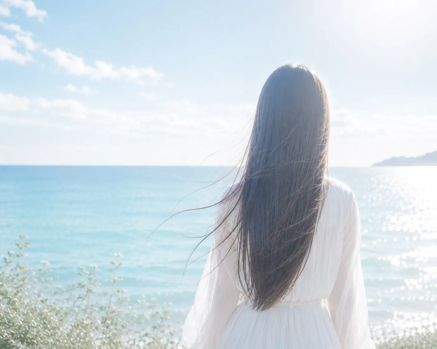 海を背景にしたロングヘアの女性の後ろ姿